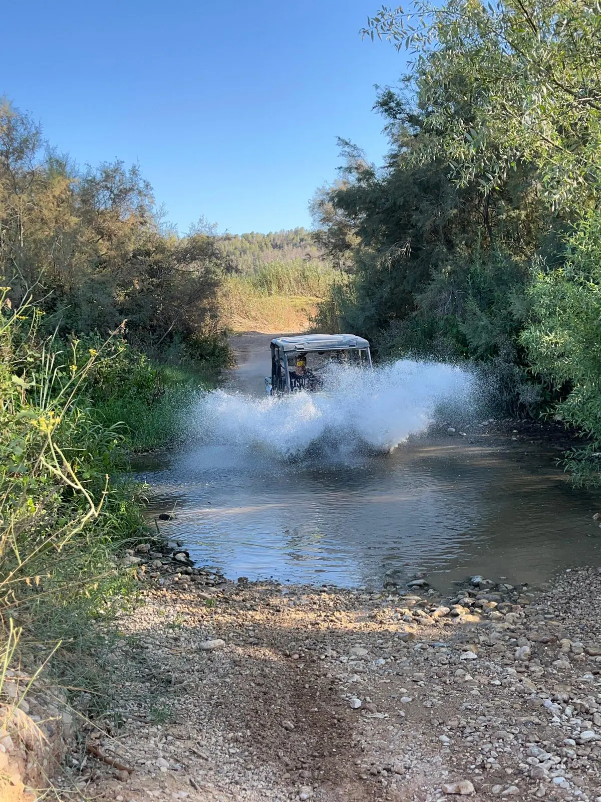 Buggy blasting through a water crossing, spray everywhere